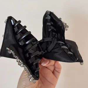 Black satin bow hair claw clip detail, elegant rhinestone edge design for women and girls.