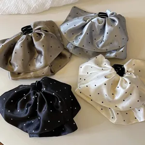 Vue rapprochée détaillée d'élégantes pinces à cheveux en satin à pois de style français variées.