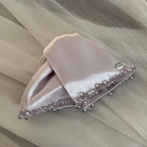 Satin triangle hair claw clip with beaded edge and metal tag detail for elegant daily styling.