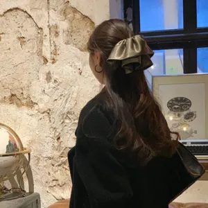 Vue détaillée de l'élégante pince à cheveux en satin à pois, avec un design à volants superposés.
