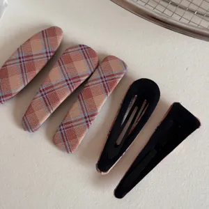 Vista detallada de pinzas para el cabello de cuadros vintage, horquillas de tela.