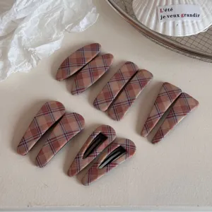 Primer plano detallado de pinzas para el cabello de tela a cuadros retro, accesorios.