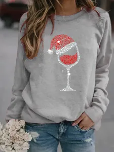 Detailed view of grey crewneck sweatshirt featuring a sparkling Christmas wine glass rhinestone print.