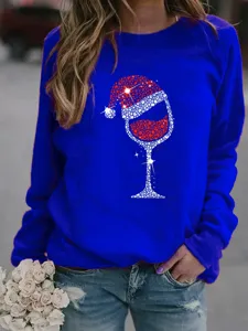 Close-up detail of women's blue Christmas wine glass print sweatshirt worn with jeans.