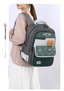 Close-up detail of the color-block school backpack with cute bear pendant and side pocket.
