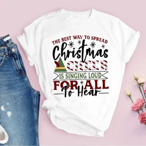 Gros plan détail du t-shirt blanc avec impression de texte de Noël et design festif.