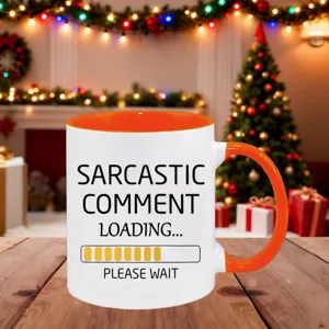 Close-up detail shot of a funny ceramic coffee mug with orange interior on wooden table.
