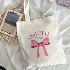 Grand sac cabas en toile blanche avec joli noeud rose pour un usage quotidien.