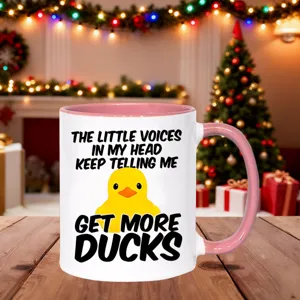 Detailed view of a cute ceramic coffee mug with pink handle and funny duck graphic quote.