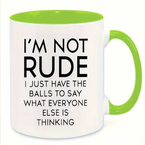 Close-up detail of a white ceramic coffee mug with bright green handle and interior quote text.