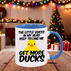 Close-up detail view of ceramic coffee mug with cute yellow duck and funny quote text.