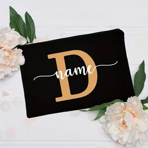 Custom letter makeup bag detail, black canvas cosmetic pouch with floral background display.
