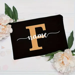 Black canvas cosmetic pouch with gold letter F and white custom name print, floral detail.