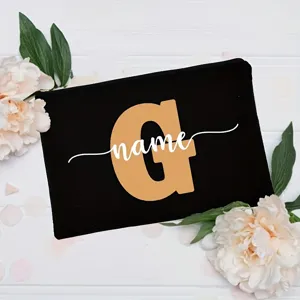 Detailed shot of a black canvas cosmetic bag featuring a custom initial G and floral decor.