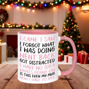 Detailed view of a funny quote ceramic coffee mug with pink handle in cozy holiday setting.