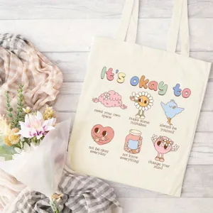 Canvas tote bag detail featuring colorful mental health quotes and cute retro illustrations.