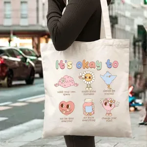 Detailed view of white canvas tote bag with mental health quotes and cute retro illustration.