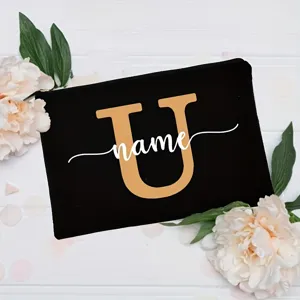 Close-up of black canvas cosmetic bag with customizable letter and floral background.