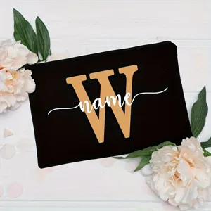 Detail view of custom black makeup pouch featuring a gold letter W and white name print.