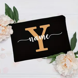 Custom black floral canvas clutch bag detail, showing elegant white flower decoration and letter.