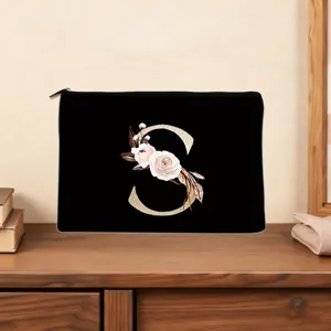 Detailed view of black personalized floral letter S cosmetic pouch, elegant makeup clutch bag.