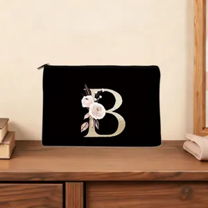 Black cosmetic pouch featuring a elegant gold letter B and floral print, detailed close-up.