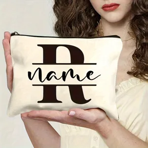 Closeup detail of custom canvas makeup bag featuring monogram letter and secure zipper closure.