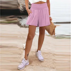 Dettaglio pantaloncini casual rosa a vita alta con cintura elastica e tessuto da spiaggia.