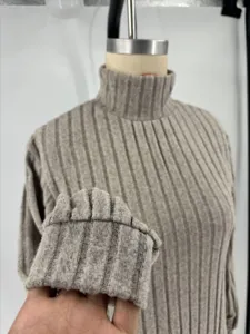 Ribbed knit turtleneck sweater dress cuff detail closeup, soft fabric texture view