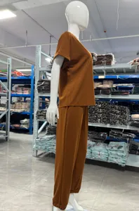 Detailed view of the casual solid color short-sleeve top and pocket pants set in warehouse.