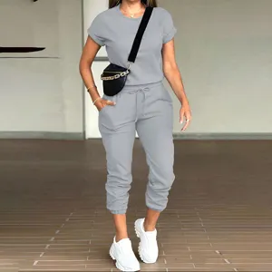 Casual women two-piece tracksuit solid color short sleeve top and pocket sweatpants.