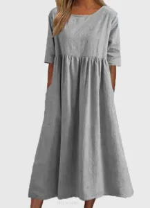 Detalle del vestido midi informal de lino gris con prácticos bolsillos y escote redondo.