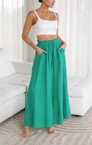 Detail view of casual loose wide-leg pants in vibrant green with high waist and pockets.