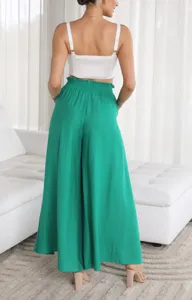 Detail view of women's high-waisted green wide-leg trousers, casual style in indoor setting.