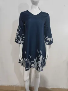 Detailed view of the navy blue mini dress featuring white leaf prints on sleeves and hem.