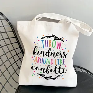 Detailed view of white canvas tote bag featuring colorful inspirational letter print design.