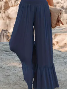 Detail view of women's navy blue pleated wide-leg pants featuring high waist and cute ruffles.