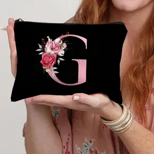 Black canvas cosmetic bag featuring pink floral letter G, ideal for daily makeup storage.
