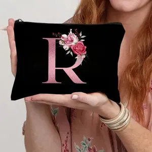 Black canvas cosmetic bag with rose gold letter R and floral print, perfect for daily use.
