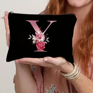 Close-up detail shot of the black canvas cosmetic bag featuring a pink floral letter Y design.
