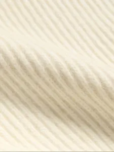 Close-up detail of women's ribbed knit sweater fabric, soft texture, autumn winter apparel