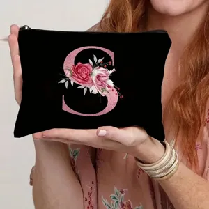 Detailed view of the black canvas cosmetic pouch featuring a pink floral letter S print.