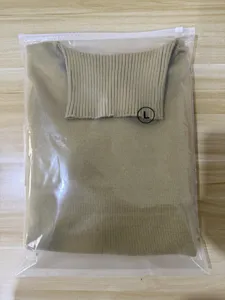 Detailed view of a classic khaki turtleneck sweater, neatly folded in a clear packaging bag.