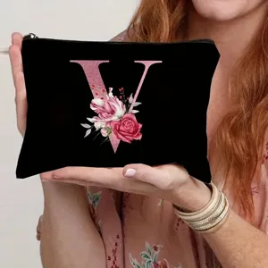 Detailed close-up of a black canvas cosmetic pouch featuring a pink floral letter V print.