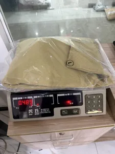 Detail view of khaki turtleneck knit sweater packaging, shown on scale for weight check.