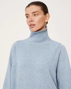Close-up detail of light blue turtleneck sweater showcasing soft knit texture and ribbed collar.