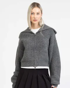 Close up detail of grey zip up knit cardigan showcasing wide lapel collar and metal zipper.