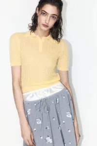 Close-up view of the yellow short sleeve polo knit sweater showcasing delicate hollow-out texture.