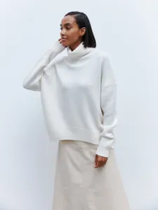 Close-up of the soft white turtleneck sweater featuring long sleeves and ribbed cuffs.