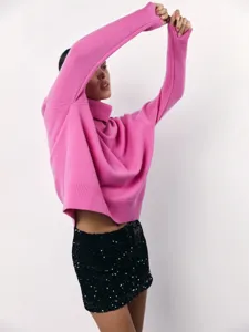 Close-up detail of cozy pink oversized turtleneck sweater, soft knit texture and stylish fit.